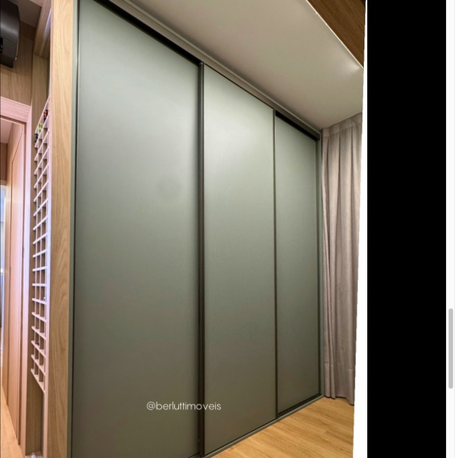 Closet com portas de correr em vidro fumê e estrutura em madeira clara