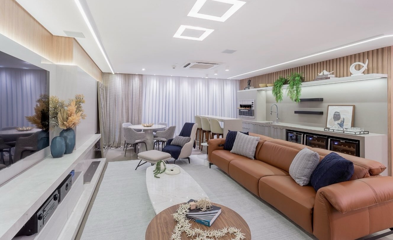 Sala integrada com painel de TV, bancada e adegas embutidas